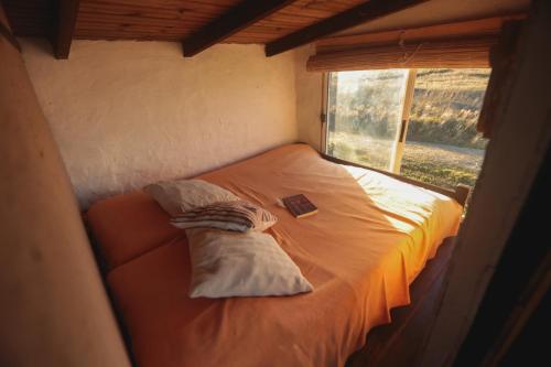 a small bed in a room with a window at Ventanas al Mar in Cabo Polonio