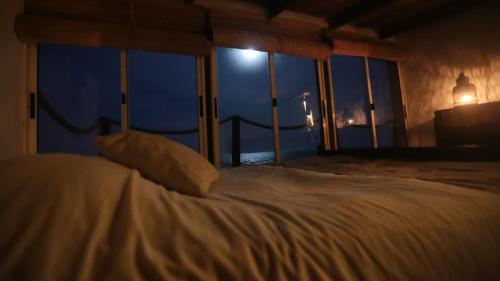 a bedroom with a bed with a view of the ocean at Ventanas al Mar in Cabo Polonio