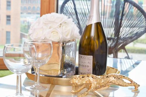 a table with a bottle of wine and glasses at Deluxe City Centre Apt Balcony View and Free Parking in Hunslet