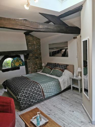 - une chambre avec un lit et un mur en pierre dans l'établissement La Chambre de La Pomerie, à Chiché