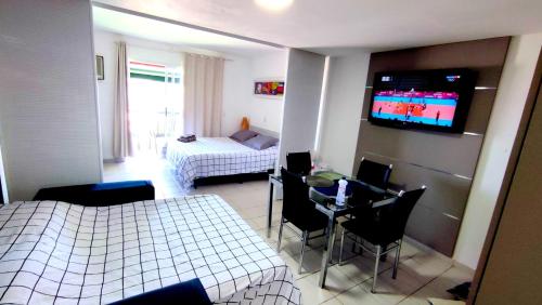 a bedroom with a bed and a room with a tv at Flat frente mar no Shopping Piratas , com estacionamento gratuito in Angra dos Reis