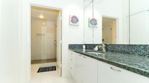 a white bathroom with a sink and a mirror at Harbor Villa Club 309 in Longboat Key