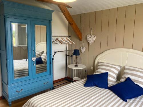 1 dormitorio con armario azul y cama en La Casa Cantarana, en Le Teich