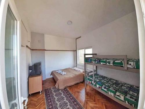 a bedroom with two bunk beds and a television at Apartments "La Štabe" - Kruševo in Kruševo