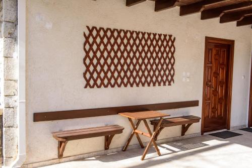 einen Tisch und zwei Bänke neben einer Wand in der Unterkunft ΔΗΜΗΤΣΑΝΑΣ ΤΟΠΟΣ Νύμφη Θεισόα in Dimitsana