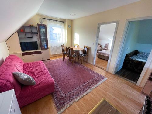 a living room with a red couch and a table at Vikendica Kostic in Zlatibor