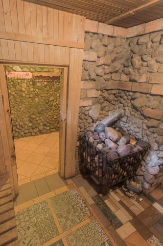 a stone fireplace in a room with a stone wall at Super Sodyba in Pamusiai