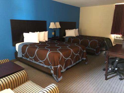 a hotel room with two beds and a desk at Amerivu Inn & Suites in Eau Claire