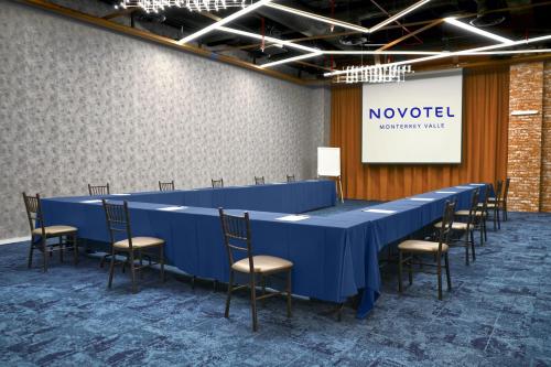 a long blue table and chairs in a room at Novotel Monterrey Valle in Monterrey