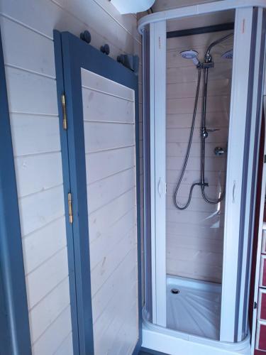 La salle de bains est pourvue d'une cabine de douche et d'une porte. dans l'établissement La Roulotte de Francine, à Chazeuil