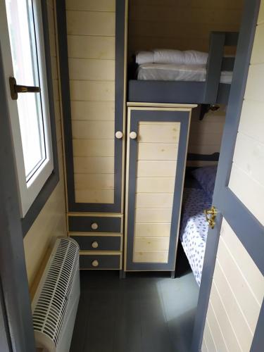 Cette petite chambre comprend des lits superposés et un placard. dans l'établissement La Roulotte de Francine, à Chazeuil