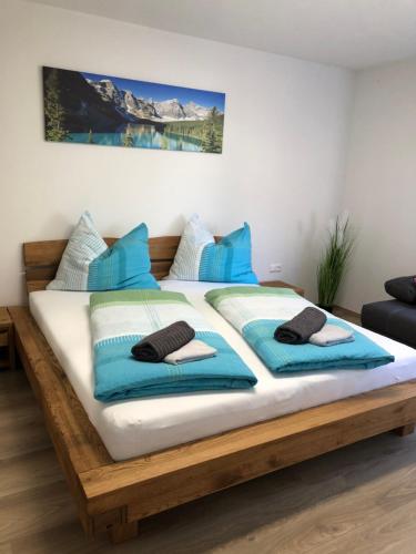 a bedroom with a bed with blue pillows on it at Ferienwohnung CeLina in Lienz
