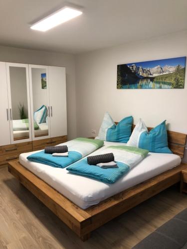 um quarto com uma cama grande e almofadas azuis em Ferienwohnung CeLina em Lienz