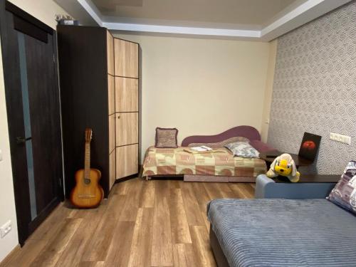 een slaapkamer met twee bedden en een gitaar erin bij Apartment 30 m2 on Sergei Esenin 11 in Charkov