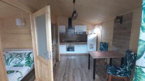 ein kleines Zimmer mit einem Bett und einem Tisch in einem winzigen Haus in der Unterkunft APARTAMENT DOMEK CAŁOROCZNY in Ciechocinek
