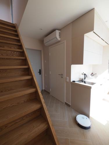uma escada num quarto com uma cozinha e um lavatório em Apartamentai Juodkrantėje Saulės smūgis 2B 65 em Juodkrantė