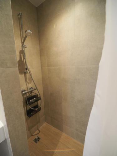 uma casa de banho com chuveiro e cabeça de chuveiro em Apartamentai Juodkrantėje Saulės smūgis 2B 65 em Juodkrantė