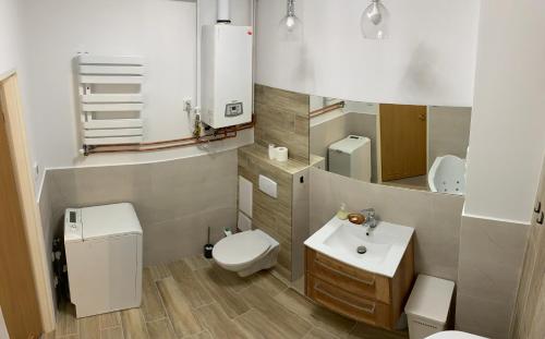 bagno con servizi igienici bianchi e lavandino di Apartamenty Stacja a Reszel