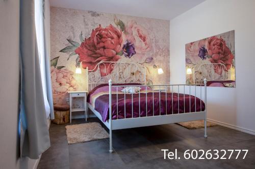 a bedroom with a bed with a floral wall at Brzozowy Zaułek in Bydlino