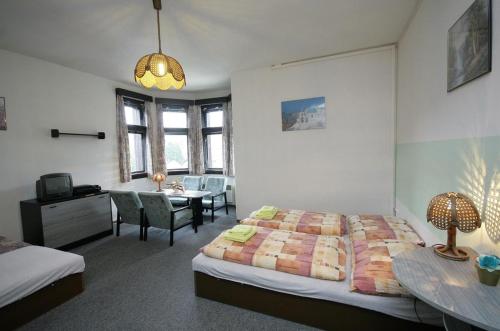 sypialnia z łóżkiem, biurkiem i stołem w obiekcie Penzion Akron w mieście Tanvald