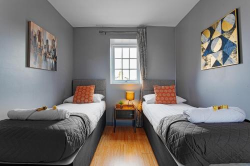 a room with two beds and a window at The Maelor - Berwyn House in Wrexham