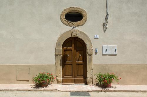 a door in the side of a building with two plants at Antica Casa del Glicine in Poggibonsi