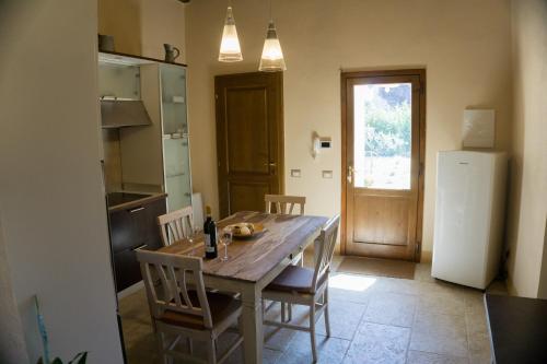 a kitchen with a table and chairs and a refrigerator at Antica Casa del Glicine in Poggibonsi