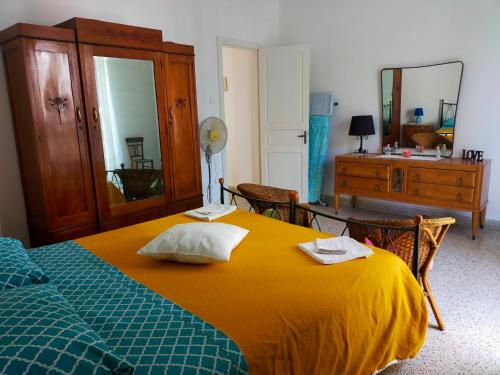 a bedroom with a bed and a dresser and a mirror at Casa Vacanze "Il Giardino" in Furnari