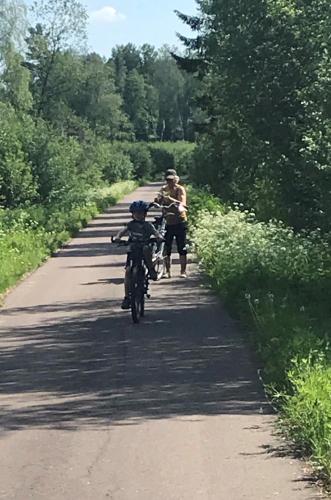 a man and a child riding a bike down a road at Härlig Heden Vakantiehuis in Råda