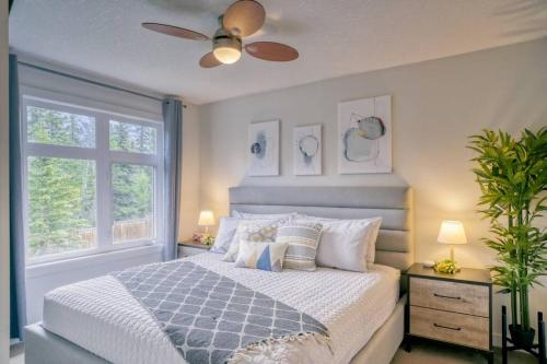 Un dormitorio con una cama y un ventilador de techo. en Cozy 2 BR - King and Queen Condo Sleep up to 6 for WFH & Vacation, en Canmore
