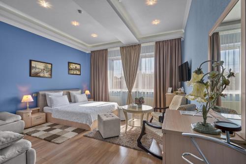 ein Schlafzimmer mit einem Bett und ein Wohnzimmer in der Unterkunft Tesoro Hotel in Rostow am Don