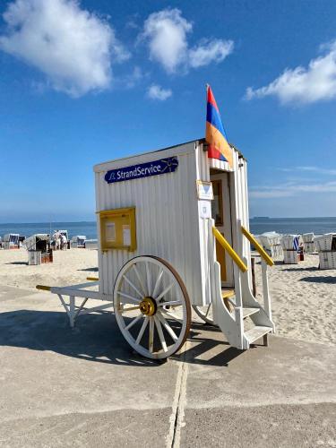 a small shack with a flag on the beach at Ferienwohnung Gustav - Moderne Maisonette-Wohnung mit Terrasse in Wangerooge