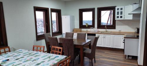 Vila Marija في كروسيفو: مطبخ مع طاولة وكراسي ومطبخ مع نوافذ