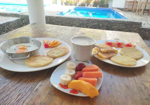 a table with two plates of breakfast food and a drink at Hotel Manakin Tayrona in El Zaino