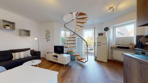 a living room with a couch and a table and a kitchen at Ferienwohnung Gustav - Moderne Maisonette-Wohnung mit Terrasse in Wangerooge