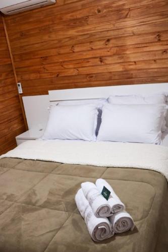a bed with two rolled up towels on it at Império Cabanas in Urubici