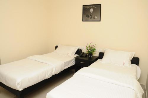 two beds sitting next to each other in a room at Balaji Residency in Chennai
