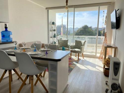 uma cozinha e sala de estar com mesa e cadeiras em La Serena Costa em La Serena