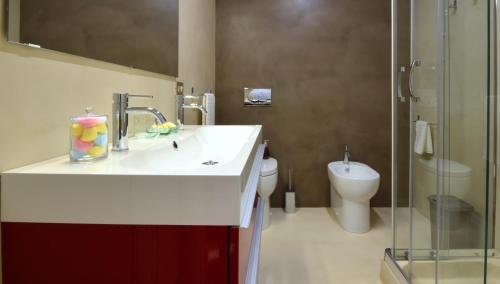 a bathroom with a sink and a toilet at Angelina Urban Lodge in Tolentino