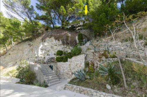 a stone building with stairs on a hill at Apartmani Mares - 20 m from the beach in Brela