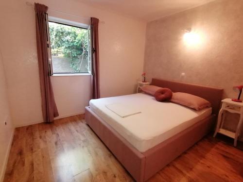 a small bedroom with a bed with a window at Apartmani Mares - 20 m from the beach in Brela