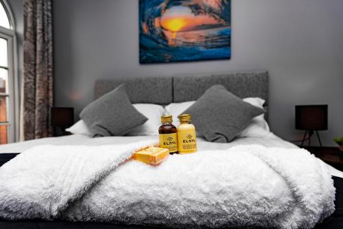 two bottles of honey sitting on top of a bed at The Glyndwr - Berwyn House in Wrexham