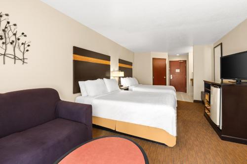 a hotel room with a large bed and a couch at Holiday Inn Express Portland SE - Clackamas Area by IHG in Gladstone