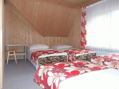a room with three beds with red and white blankets at U Justynki in Małe Ciche