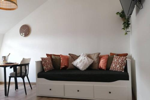 - un canapé noir avec des oreillers à côté d'une table dans l'établissement L'Ethnique Chic, à Douai