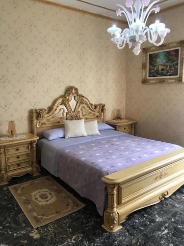 a bedroom with a king sized bed with a chandelier at VILLA FELICE in Loano