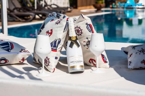a bottle of wine in a bag next to two glasses at Chiflika Family Hotel in Asenovgrad