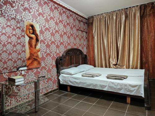 a bedroom with a bed with a painting on the wall at Смарт квартира на победе in Dnipro