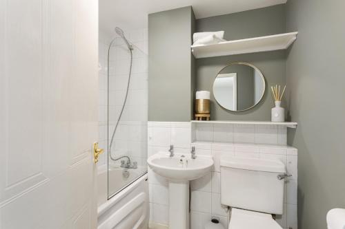 y baño con lavabo, aseo y espejo. en Olympic House en Kettering