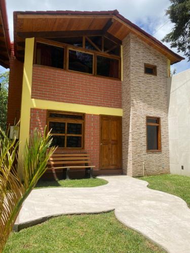 a brick house with a wooden door and a porch at CABAÑAS CASTILLO in Mineral del Monte
